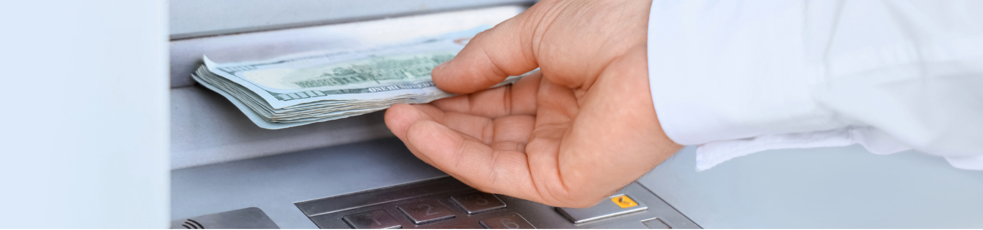 hand taking cash at atm